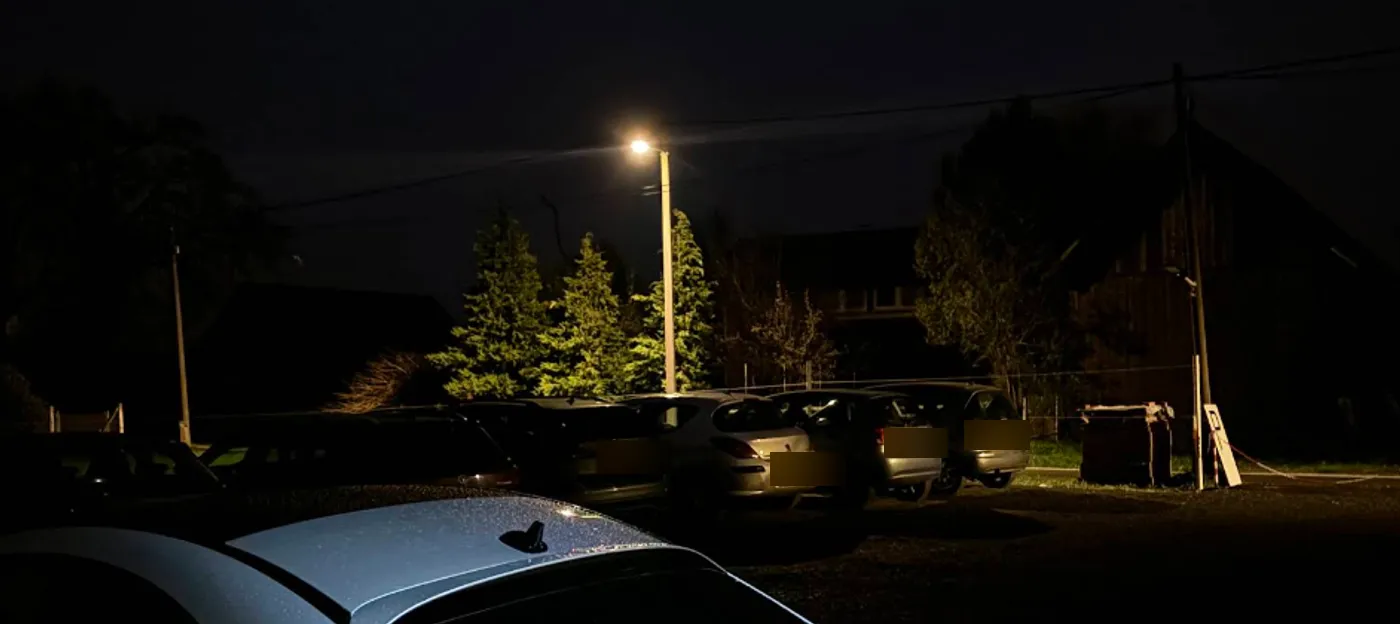 Stvarna fotografija parkinga noću: upaljena rasvjeta nad parkiranim autima